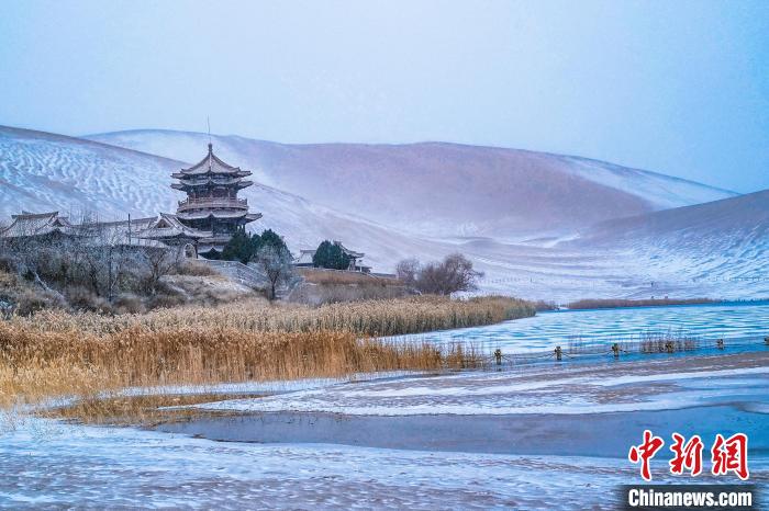 2021年11月28日，雪落鳴沙山月牙泉景區(qū)?！⊥醣筱y 攝