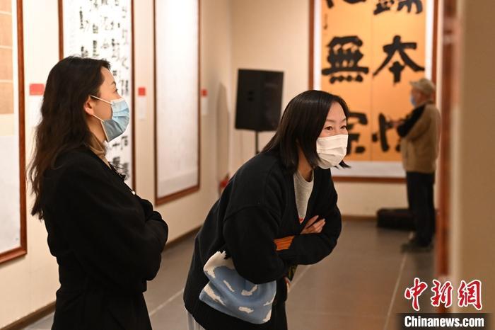 圖為甘肅蘭州，參展書(shū)法作品吸引參觀者。 中新社記者 李亞龍 攝