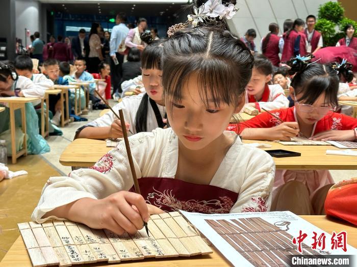 圖為小朋友在甘肅簡(jiǎn)牘博物館練習(xí)書法?！≈行律缬浾?戴文昌 攝
