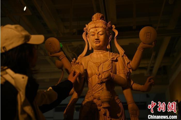 圖為季茂杰觀察自己創(chuàng)作的敦煌木雕。李亞龍 攝</p>
<p>