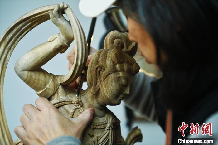 圖為季茂杰進(jìn)行敦煌元素的木雕創(chuàng)作。李亞龍 攝</p>
<p>