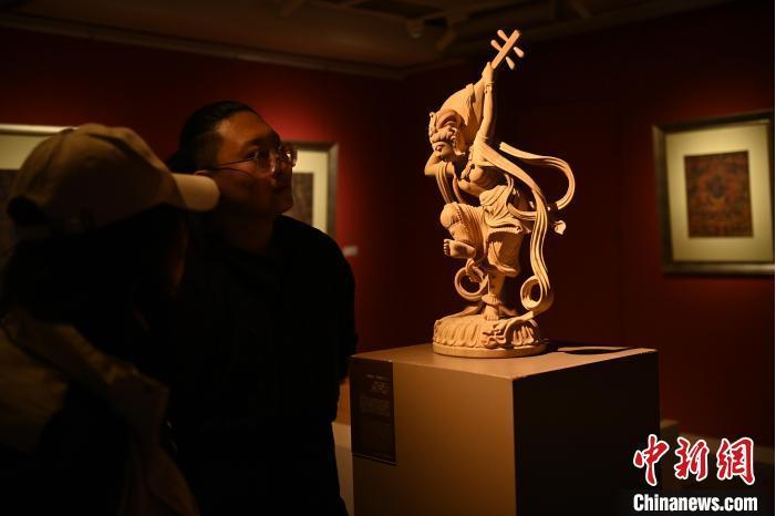 圖為季茂杰向參觀者介紹自己創(chuàng)作敦煌木雕的過程。李亞龍 攝</p>
<p>