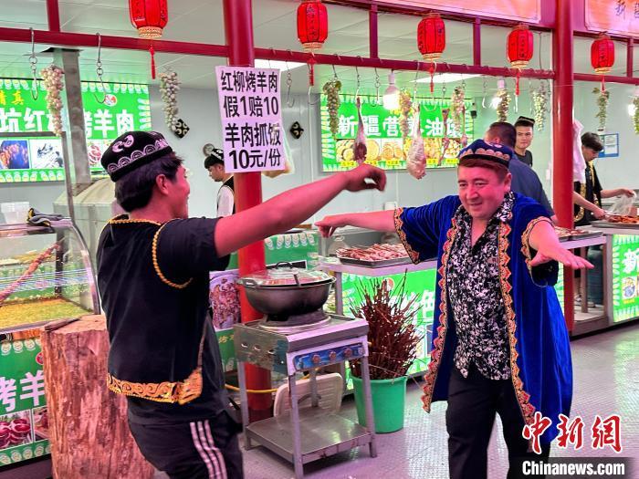 圖為餐飲經(jīng)營者在“西涼不夜城”跳起舞蹈引客?！〈魑牟?攝</p><p>